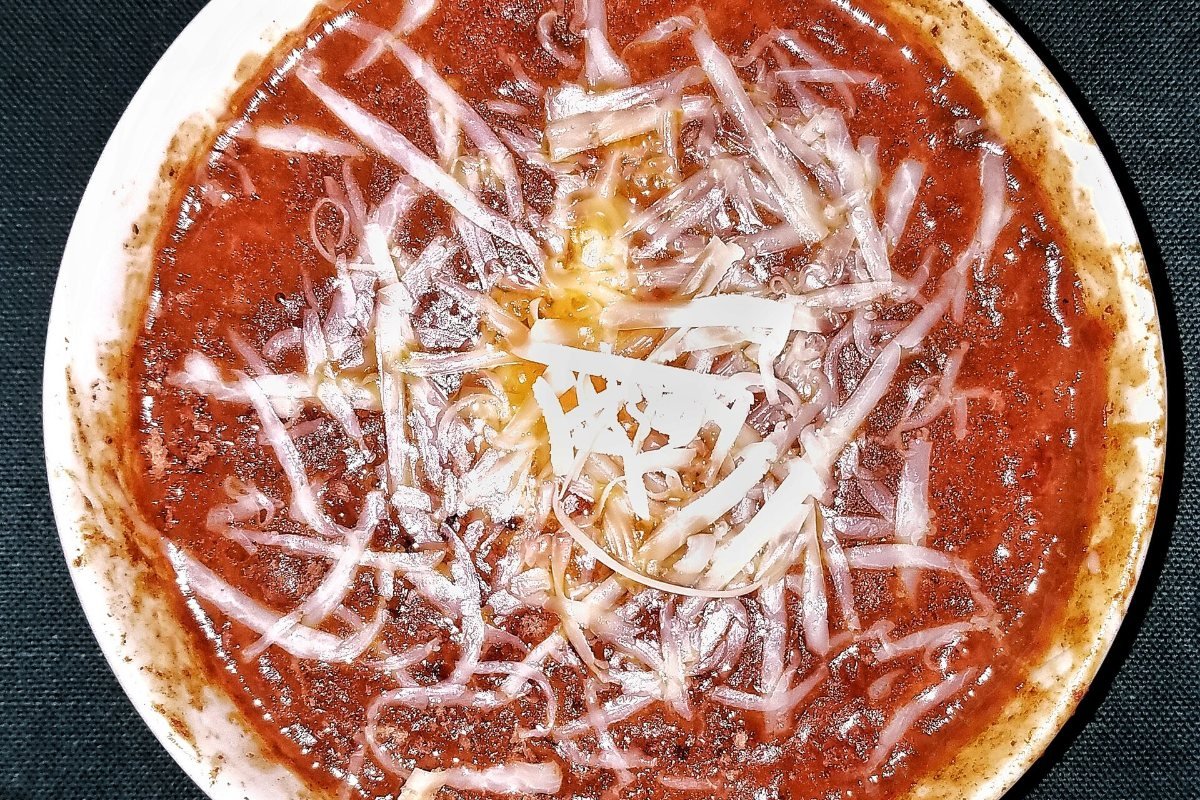 Chili con carne topped with cheddar cheese.