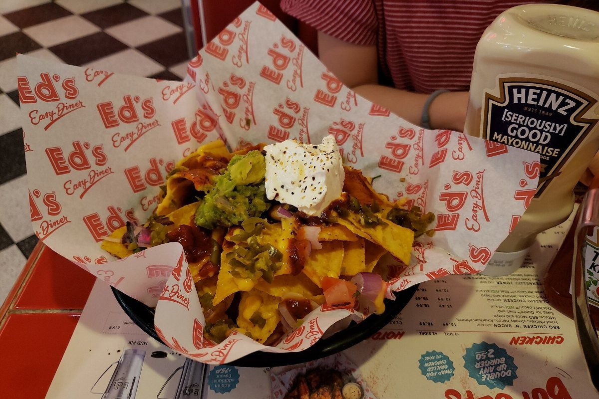 A tray of nachos with toppings.