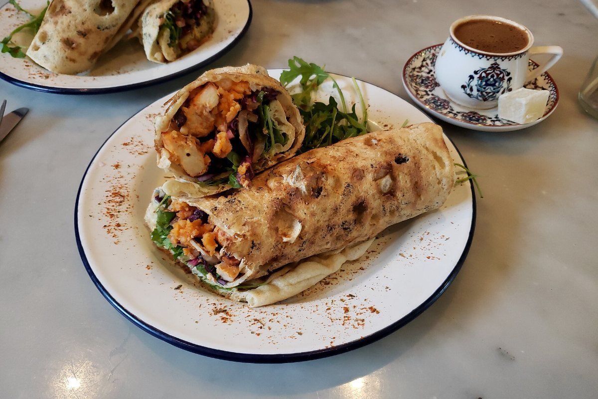 A chicken wrap with skewered meat.