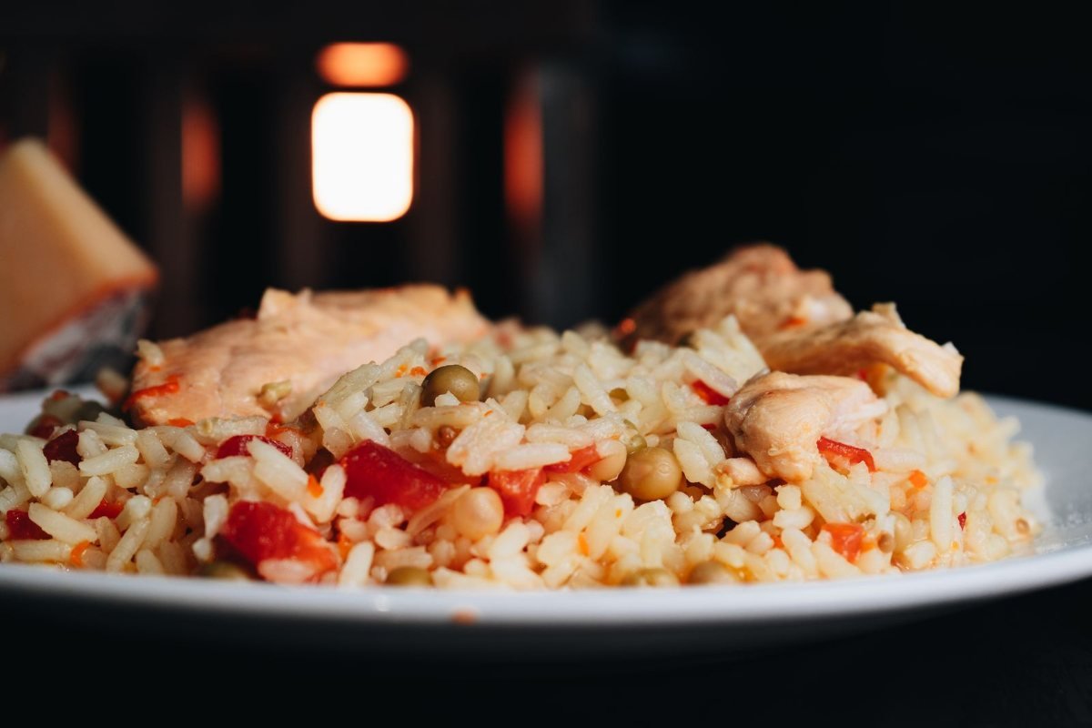 A plate of rice with chicken and vegetables.