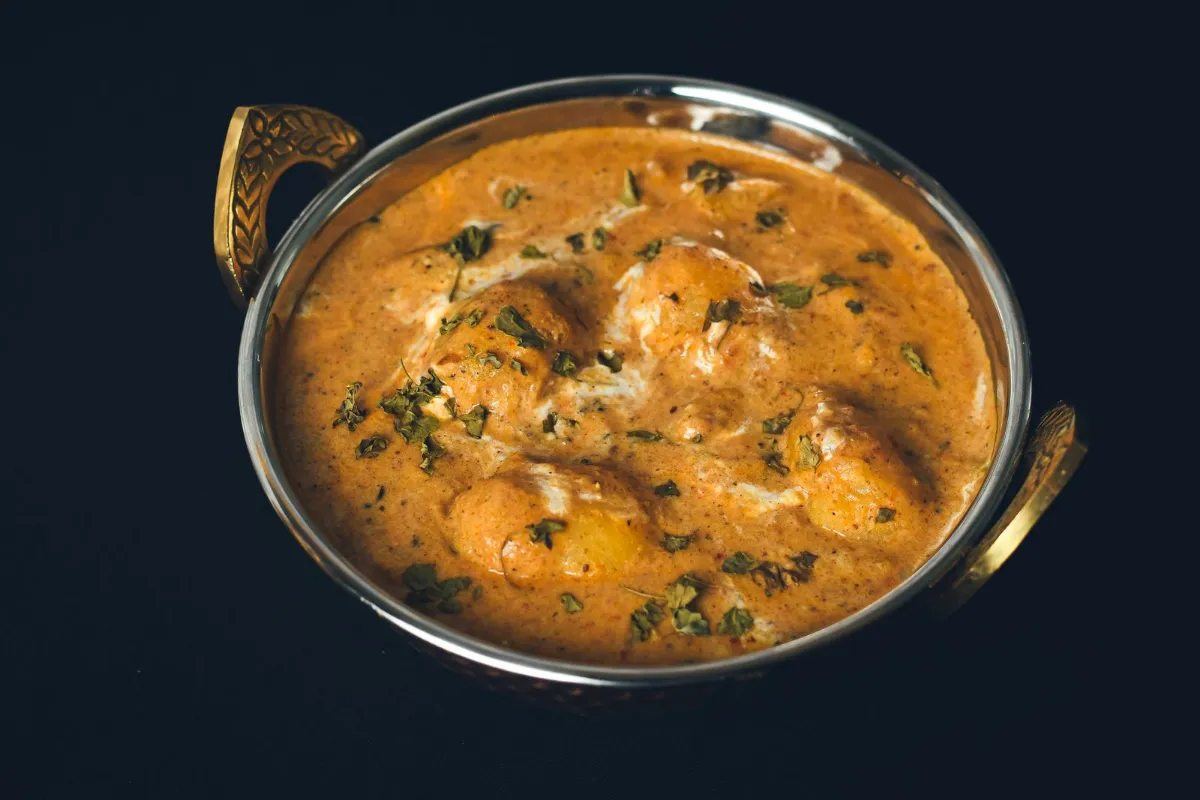 Indian dum aloo curry served in a traditional metal bowl.